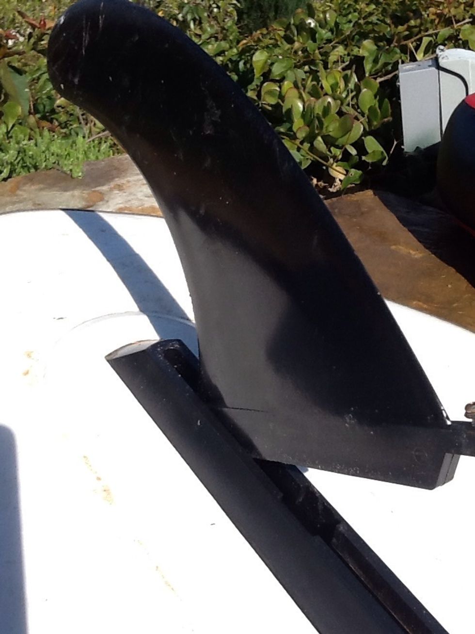 Surfer fin - Step 2 - slide the fin backwards. The brass knob should slide snugly. If not, clear any sand. A hammer may be necessary to tap the fin back.  Be careful not to crack the fin.