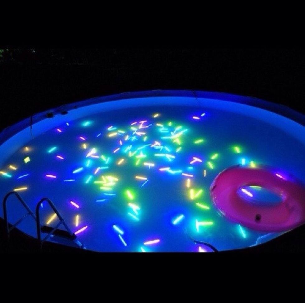 Swim in a pool full of glow sticks in the dark