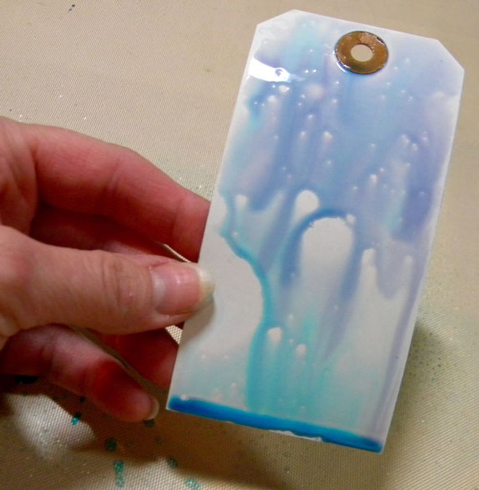 Swipe the tag into the spray and let it drip. Repeat till all the spray is gone.