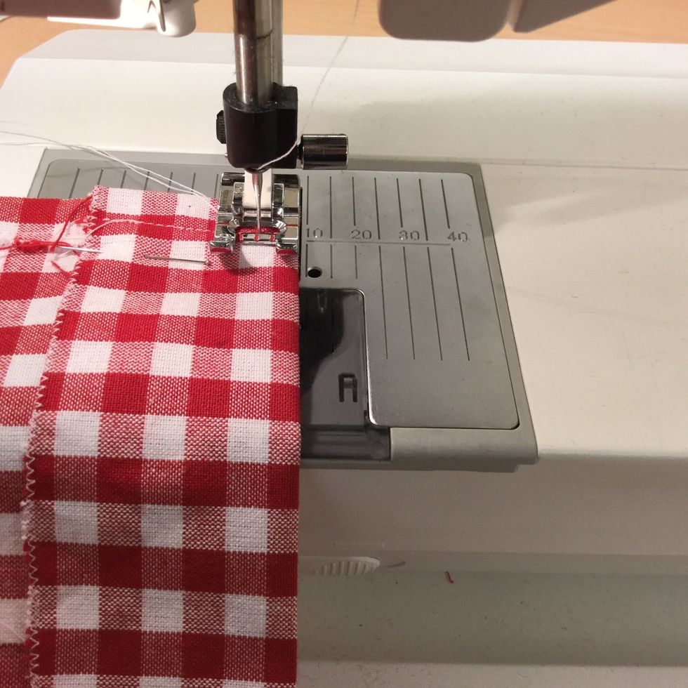 Sy en raks\u00f6m med pressarfoten vid den vikta kanten.