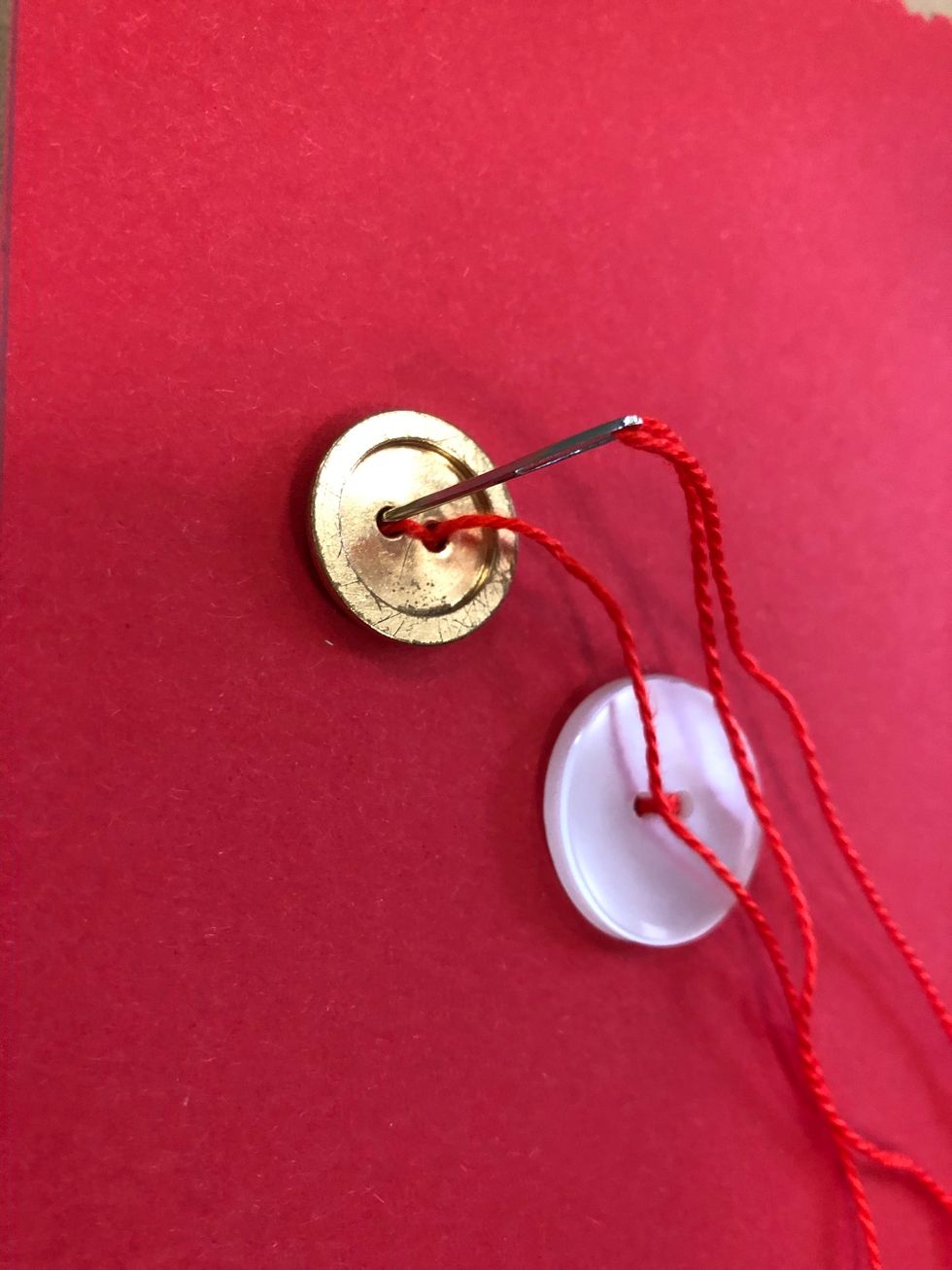 Sy fast dem p\u00e5 pappret. Sy tv\u00e5 g\u00e5nger upp och ner i samma h\u00e5l.