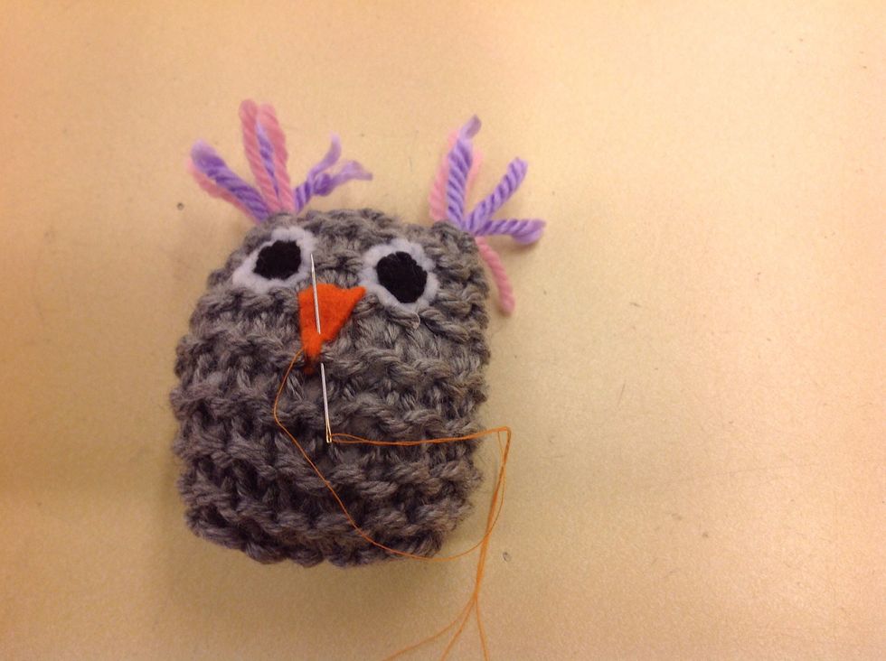 Sy fast \u00f6gon och n\u00e4bb. Anv\u00e4nd dekorationsfilt och ev knappar.