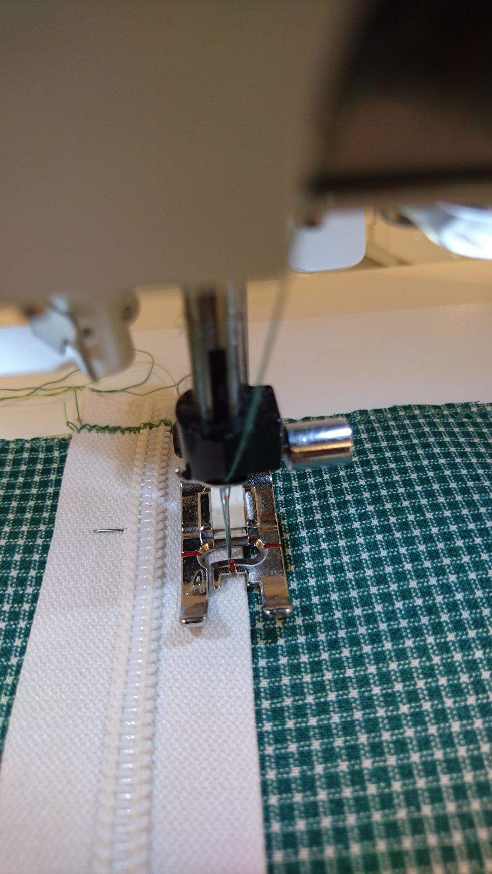 Sy i kanten p\u00e5 dragkedjan. N\u00e4r man kommer till kl\u00e4ppen, s\u00e5 stanna och ta ner n\u00e5len lyft upp pressarfoten och dra kl\u00e4ppen f\u00f6rbi pressarfoten. Se n\u00e4sta bild