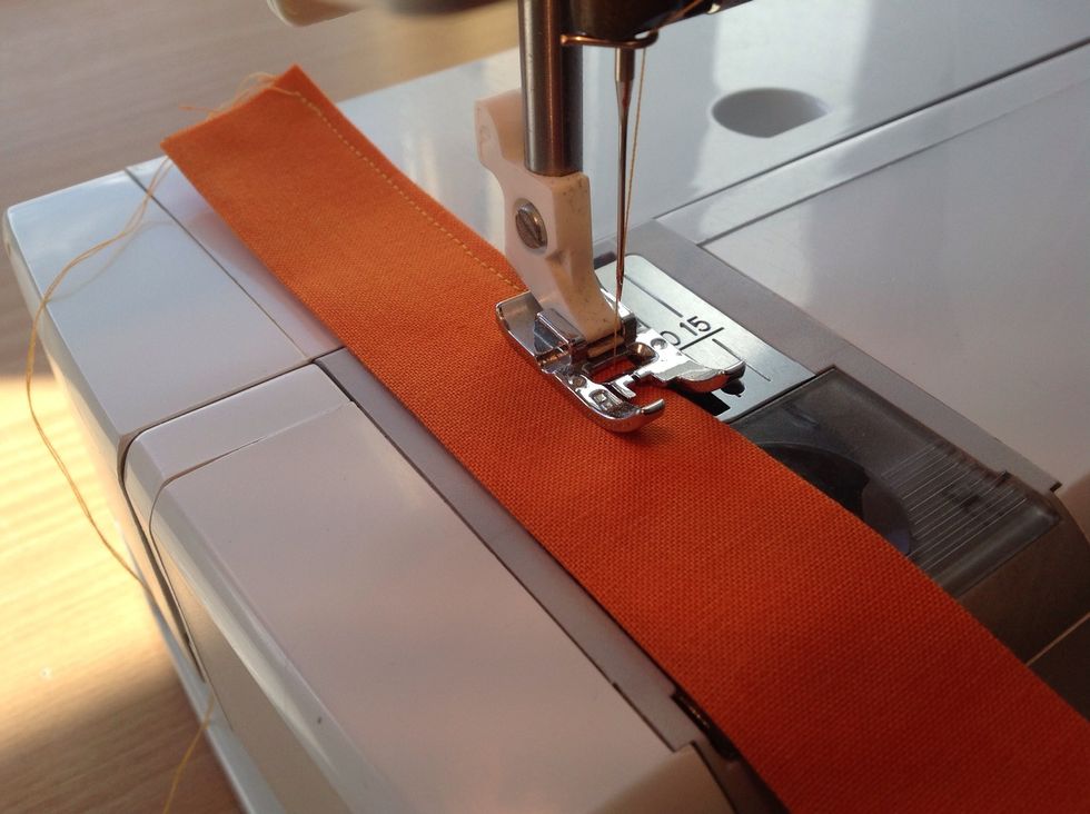 Sy ihop den \u00f6ppna kanten raks\u00f6m. Vik remsan dubbel och n\u00e5la fast den mellan botten och v\u00e4skdelen vid sids\u00f6mmen s\u00e5 att \u00f6glan hamnar p\u00e5 r\u00e4tsidan.