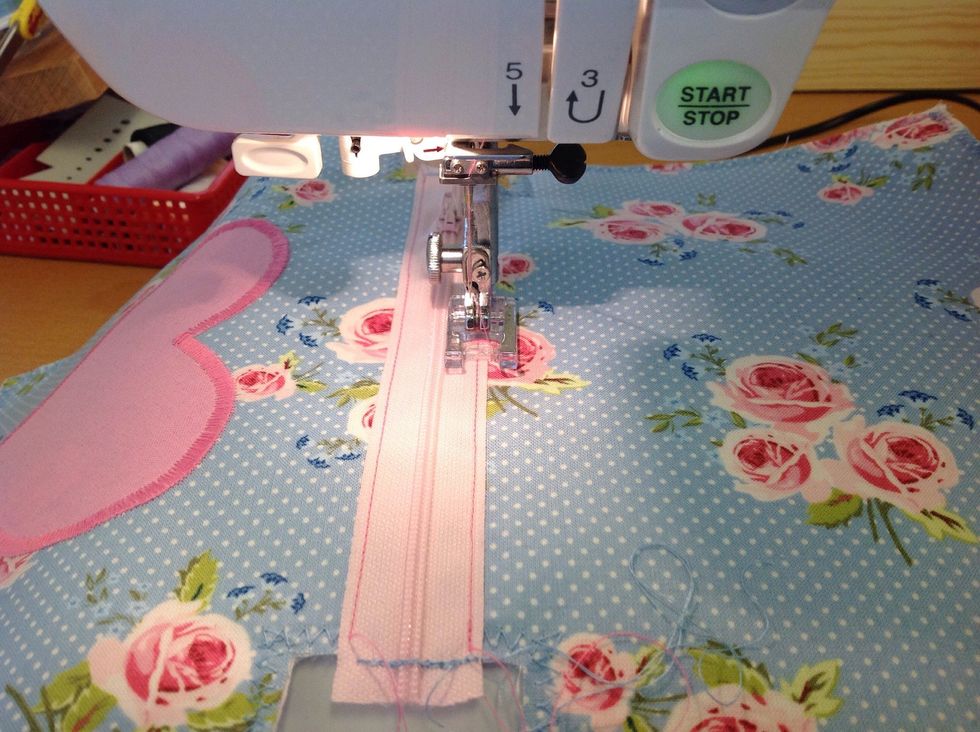 Sy med pressarfoten kloss mot dragkedjan i mitten. G\u00f6r likadant p\u00e5 b\u00e5da sidor.