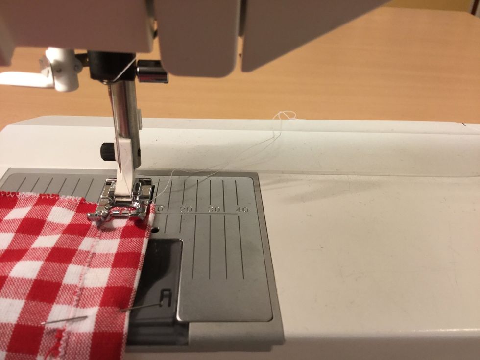 Sy med raks\u00f6m i kanten. L\u00e4gg tygkanten vid 10 mm p\u00e5 stygnpl\u00e5ten. F\u00e4st tr\u00e5den i b\u00f6rjan och i slutet.