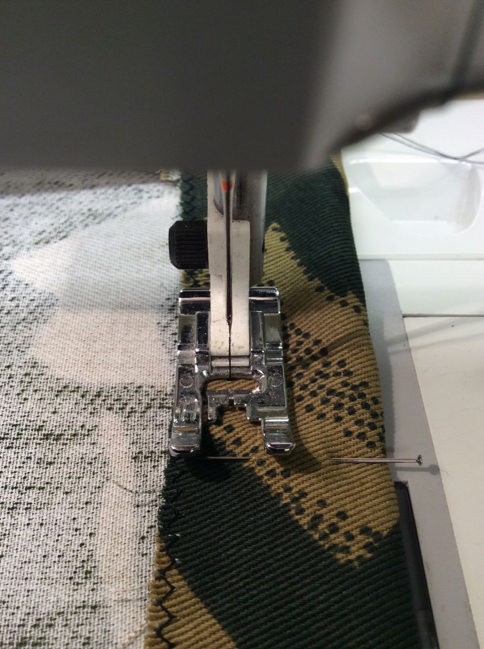 Sy med raks\u00f6m runt om hela \u00f6verkanten. S\u00f6mmen ska sys med pressarfotens kant l\u00e4ngs zick-zacken (ca 2,5 cm fr\u00e5n \u00f6verkanten). Kontrollera s\u00e5 att du inte r\u00f6r ihop hela \u00f6ppningen av misstag.