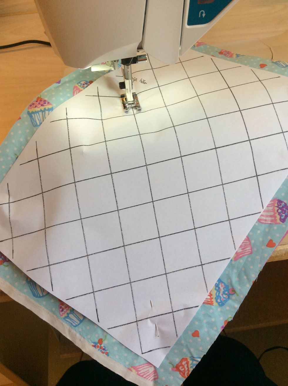 Sy raks\u00f6m i alla linjerna rakt igenom pappret och tygerna med raks\u00f6m. Gl\u00f6m inte att f\u00e4sta tr\u00e5darna i b\u00f6rjan och i slutet av varje s\u00f6m genom att anv\u00e4nda fix eller att backa.