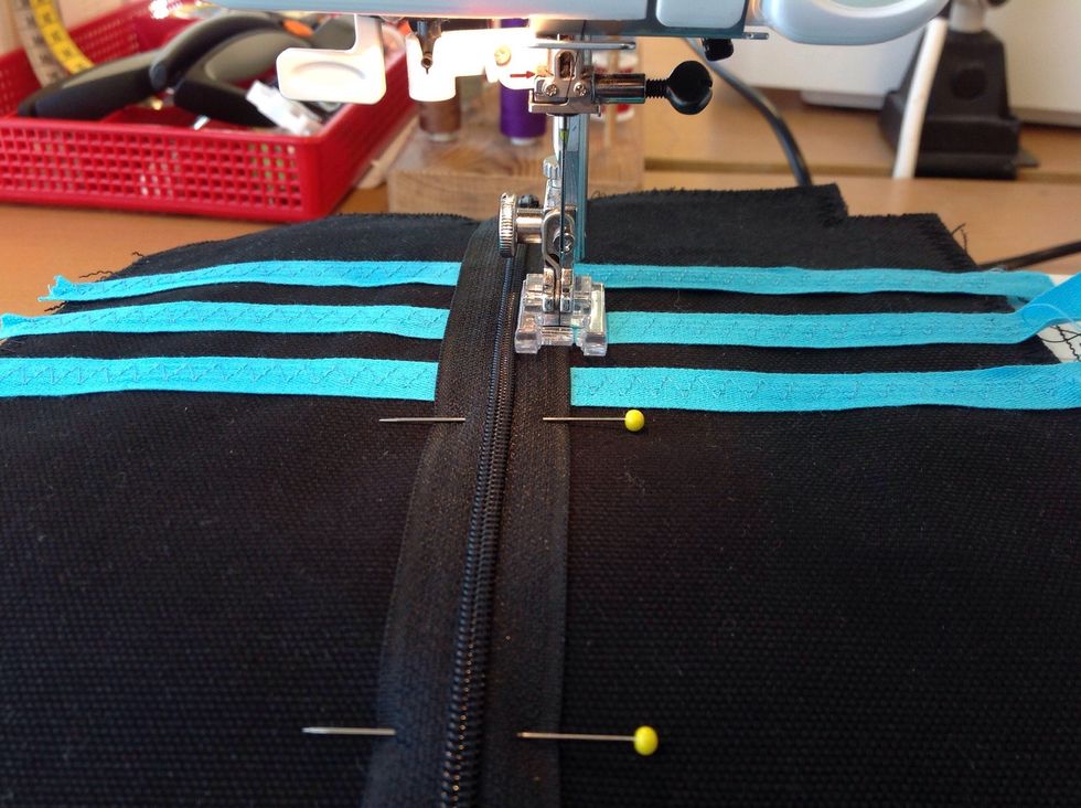 Sy raks\u00f6m i kanten av dragkedjan p\u00e5 b\u00e5da sidor.