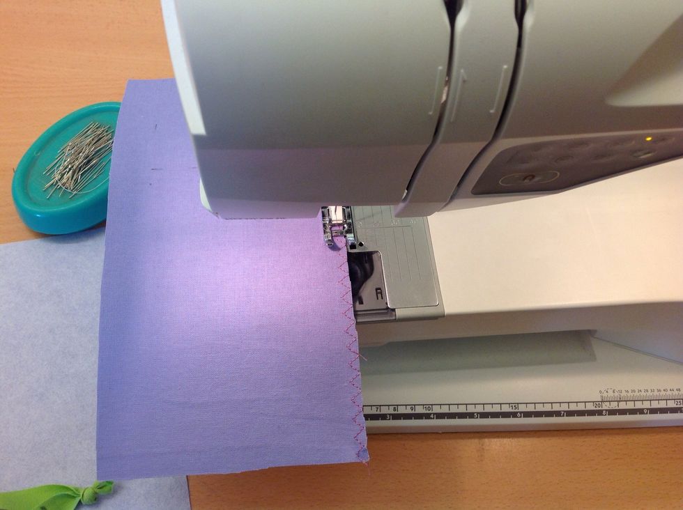 Sy s\u00e5 att s\u00f6mmen hamnar l\u00e4ngst ut i kanten. Titta hur tyget ligger vid pressarfoten f\u00f6r att hamna r\u00e4tt. Sy runt b\u00e5da dina bitar.