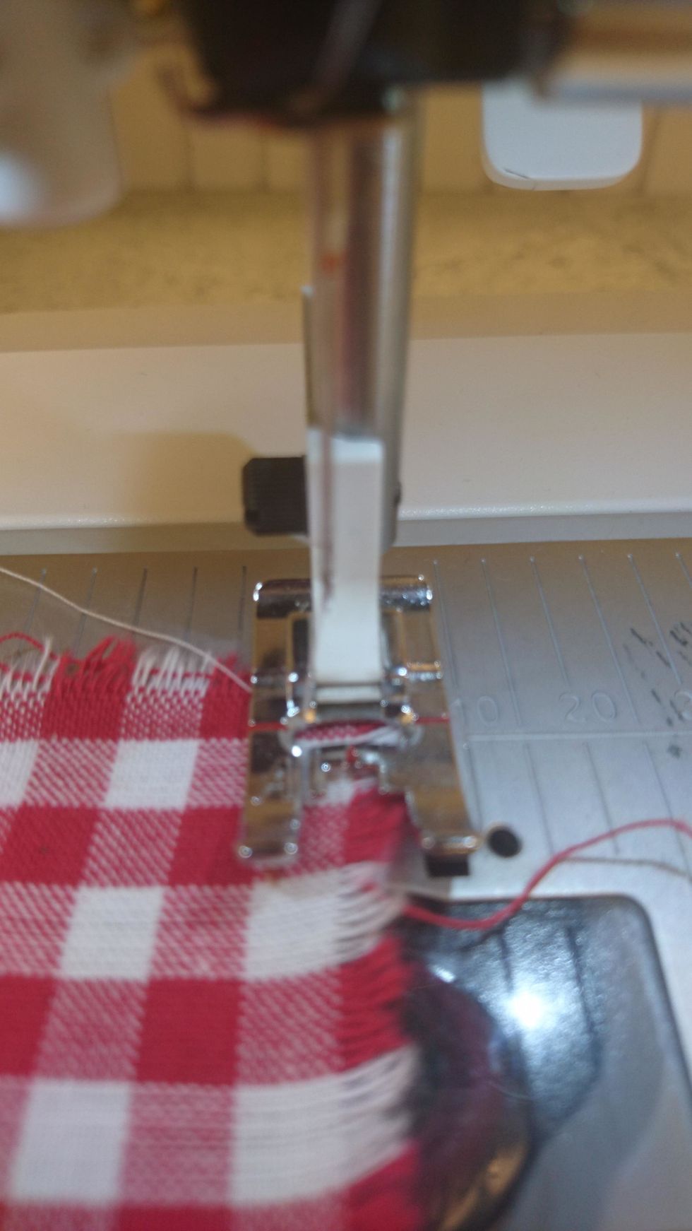 Sy sicksack runt kanten p\u00e5 tyget. Ena t\u00e5n p\u00e5 pressarfoten ska g\u00e5 utanf\u00f6r tyget.