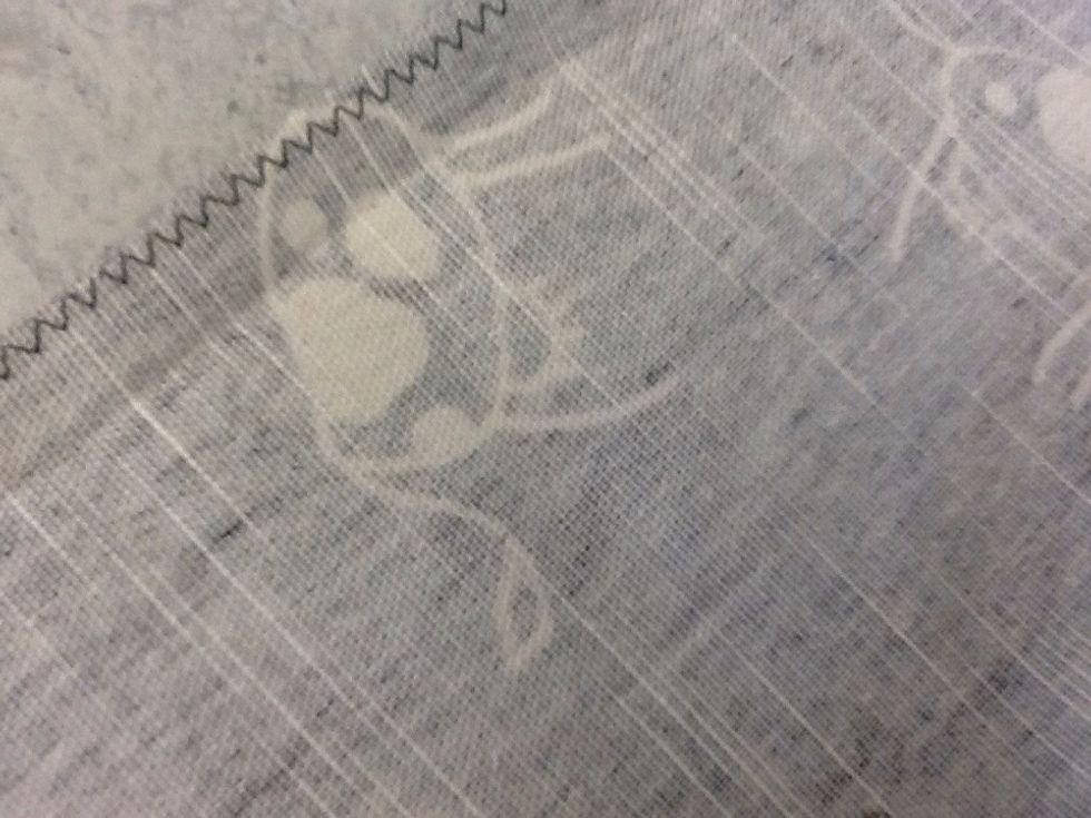 Sy sicksack runt tyget. Det blir nu en standkant p\u00e5 tyget som inte fransar sig.