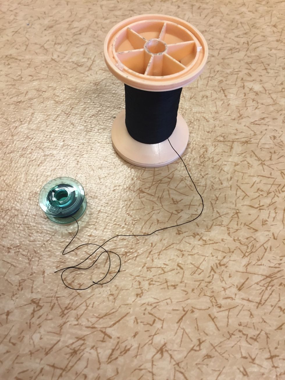 Symaskinen skall st\u00e5 p\u00e5 "av". Se till att du har en rulle med \u00f6vertr\u00e5d och en spole med undertr\u00e5d.