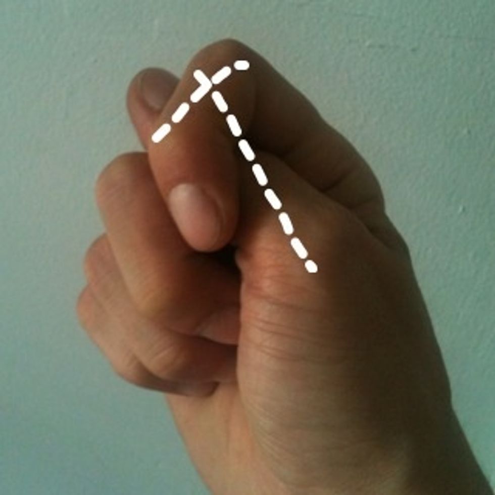 T: Tuck thumb under index finger. The thumb and index finger form a 