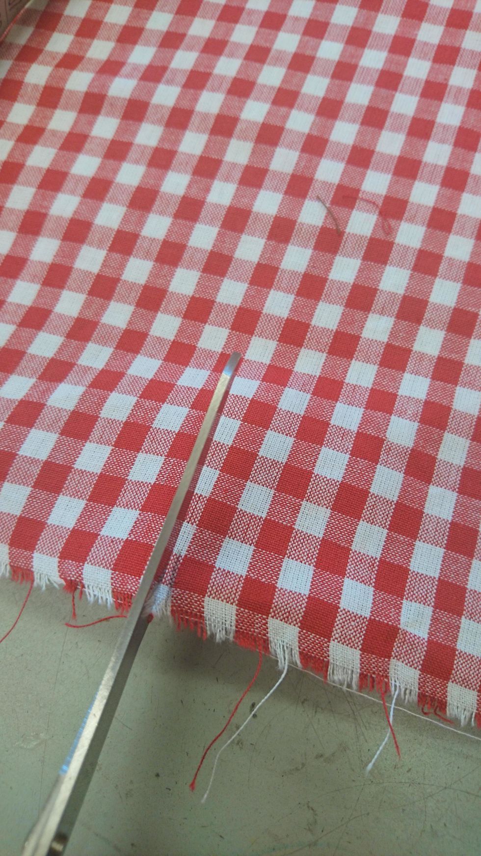 ta fram en tygsax och klipp rakt efter tygets rutor, \u00e4nda upp till kanten.