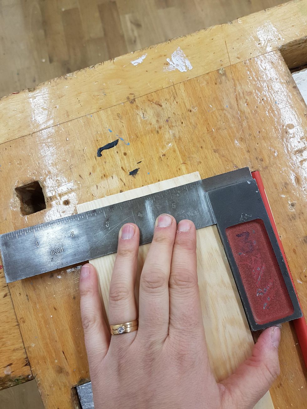 Ta fram en vinkelhake. Rita ett streck med blyertspenna s\u00e5 du vet att du har 90 grader.