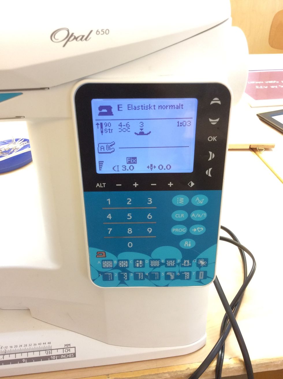 Ta fram och tr\u00e4 din symaskin. St\u00e4ll in p\u00e5 s\u00f6m nummer 3 som \u00e4r en f\u00f6rst\u00e4rkt raks\u00f6m f\u00f6r stretchiga tyger. St\u00e4ll \u00e4ven in p\u00e5 ett elastiskt normalt tyg.