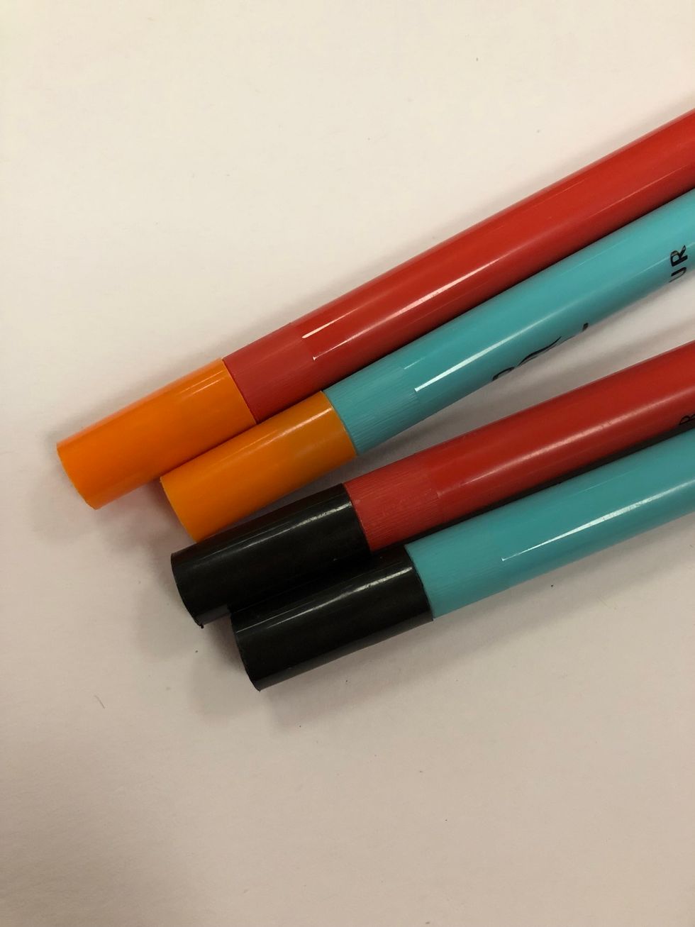 Ta fram orange och svarta pennor