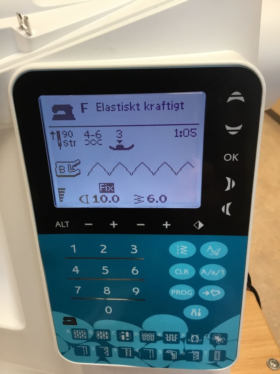 Ta fram symaskinen och tr\u00e4 den med sytr\u00e5d i samma f\u00e4rg som handduken. V\u00e4lj s\u00f6m nr 5, trestegssicksack.
