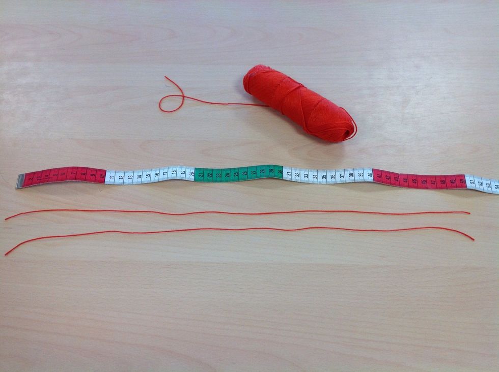 Ta fram tunt bomullsgarn och klipp av tv\u00e5 tr\u00e5dar som \u00e4r ca 100 cm l\u00e5nga.