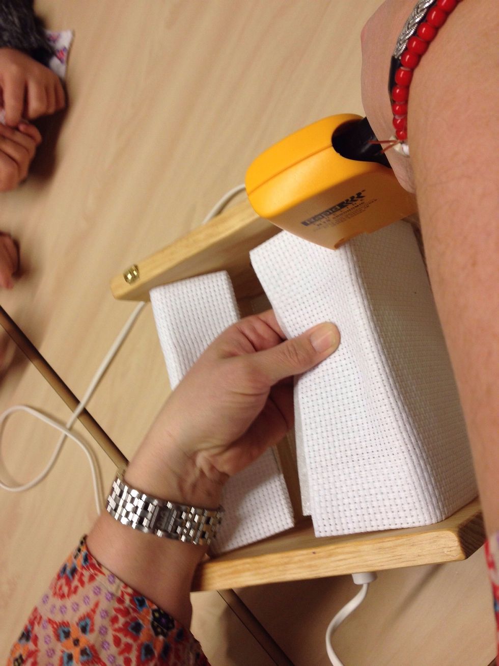 Tag nu fram h\u00e4ftpistolen och skjut fast tyget med ca 4 klamrar p\u00e5 var sida. Se till att motivet kommer mitt p\u00e5 lampan och akta dina fingrar.