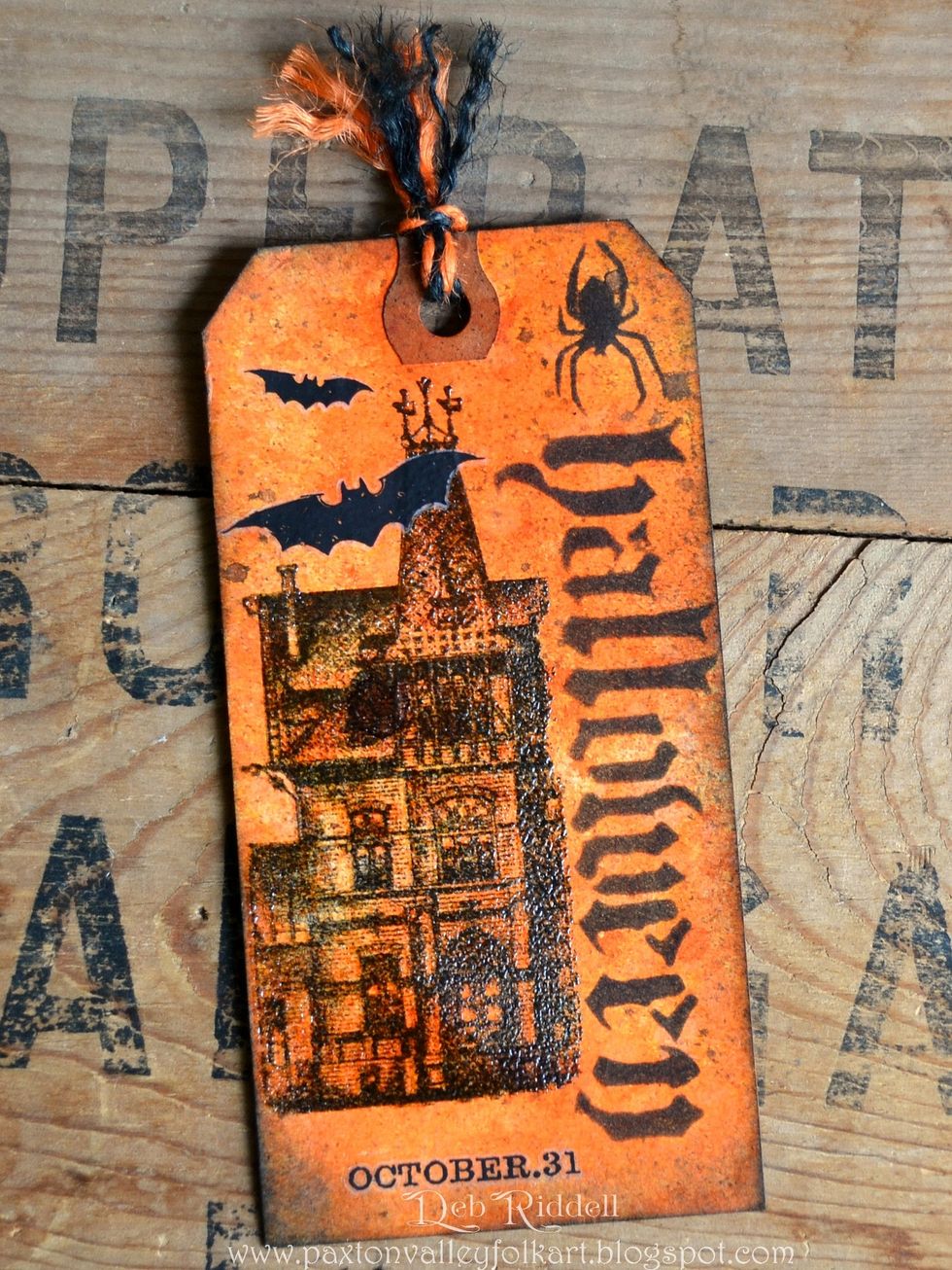 Tag time, on the front of the untrimmed tag stamp the house from Mini Halloween 5 and clear emboss. Add the bats and October 31 from Curiosities Remnant Rubs and a piece of Halloween Jute String.