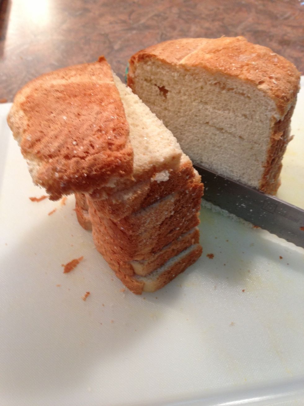 Take 1/3 to 1/2 loaf at a time.... cut in half as shown while still mostly frozen. Then you will cut other direction to form crouton strips.