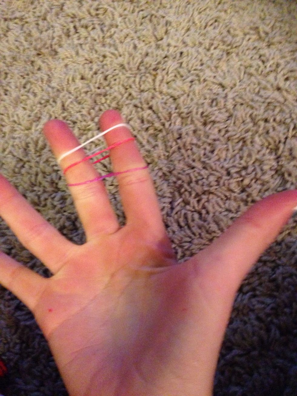 Take 1 rubber bad and make a 8 shape around your fingers then put 2 more rubber bands not in an 8 over the 8 crossed rubber band