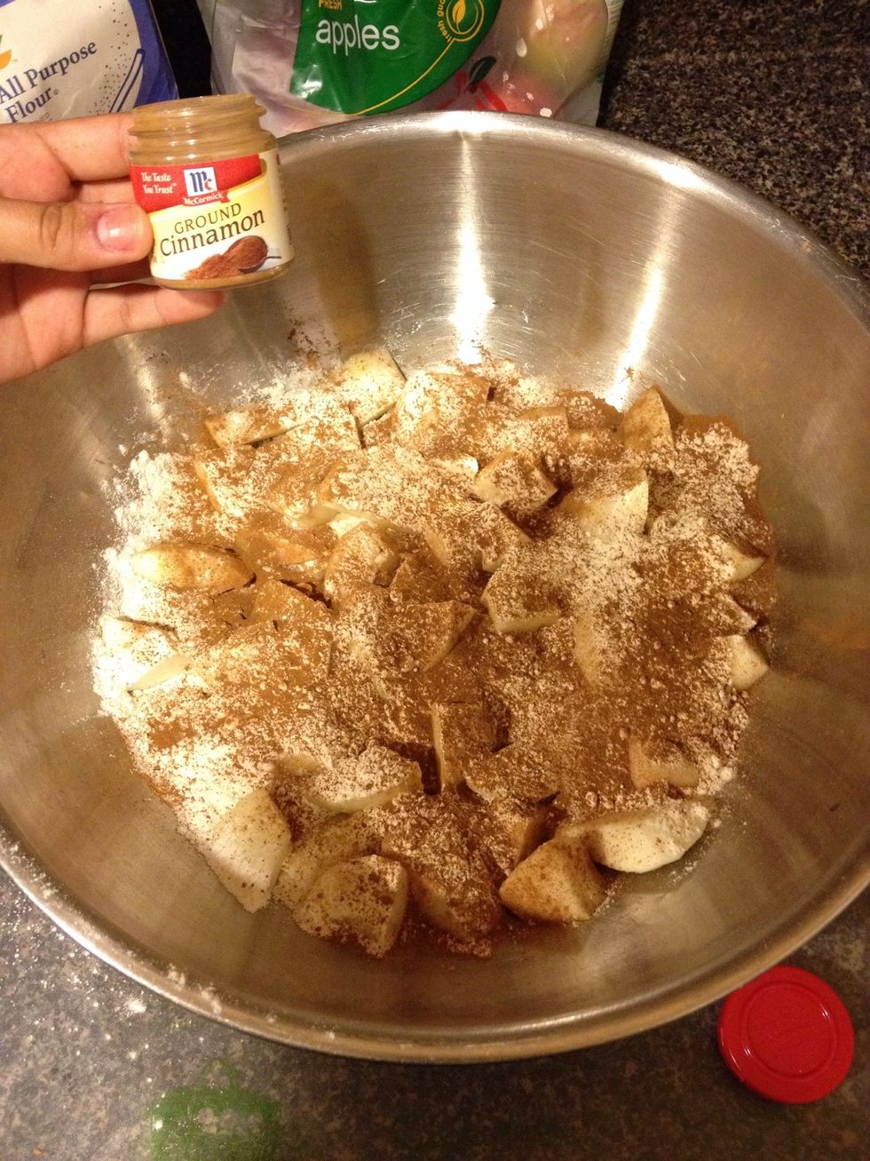 Take 1 teaspoon of ground cinnamon and sprinkle it over the sugar and flour. Proceed to mix contents together.