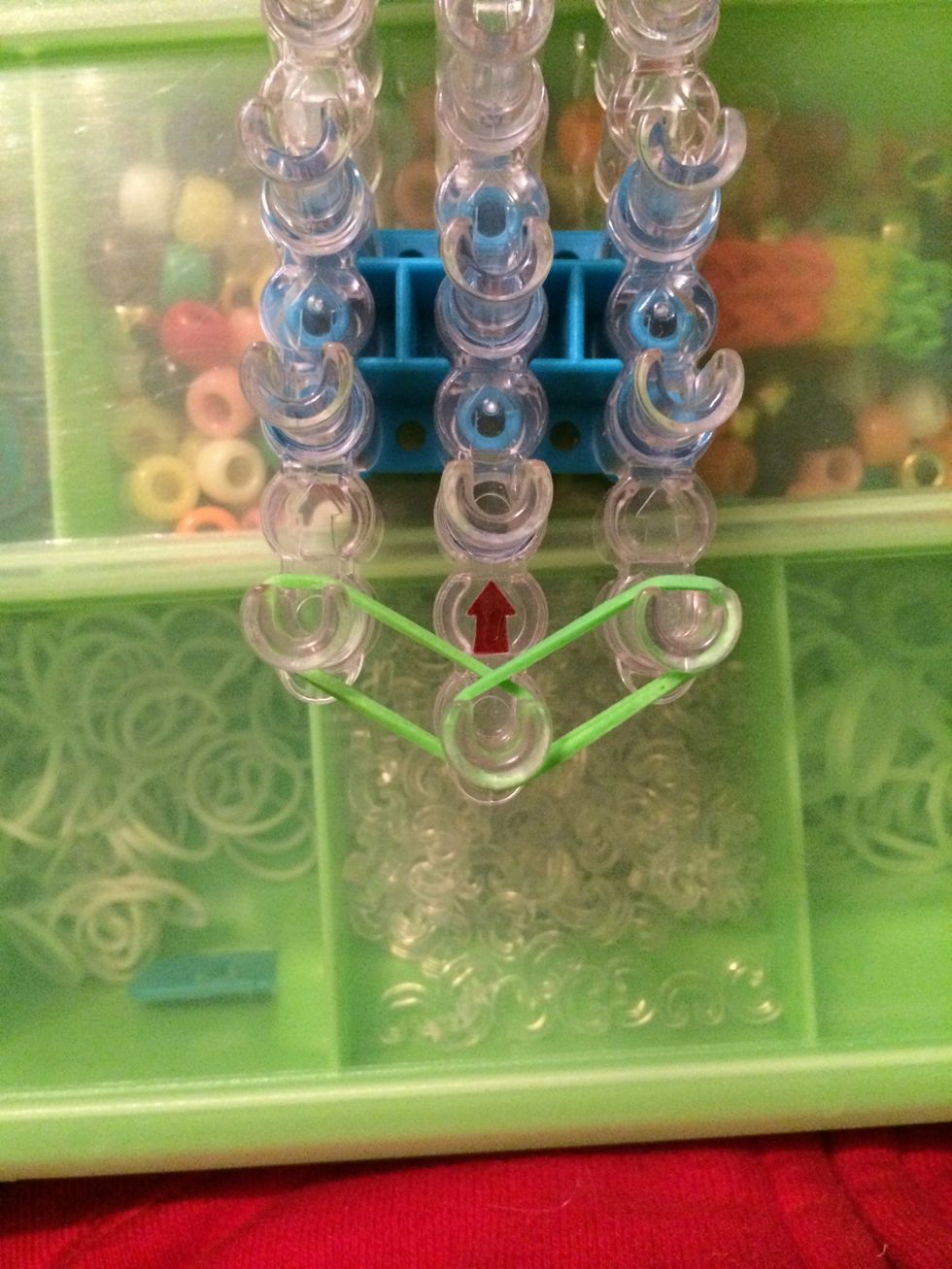 Take 2 green bands and place them over the left and center peg. Take 2 more and place them over the right and center peg.