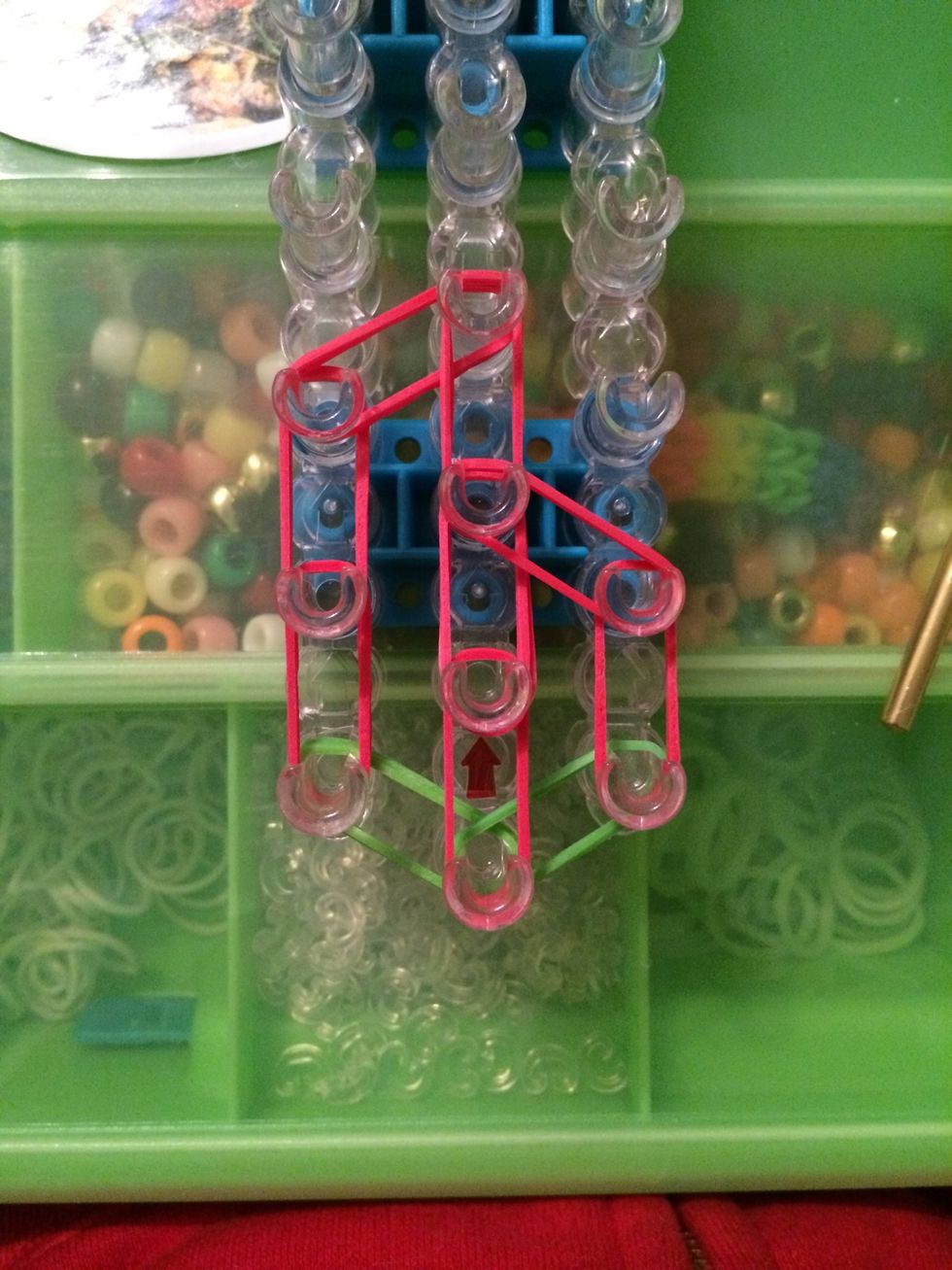 Take 2 more red bands and place them on the second peg on the right side and the third peg on the center row.