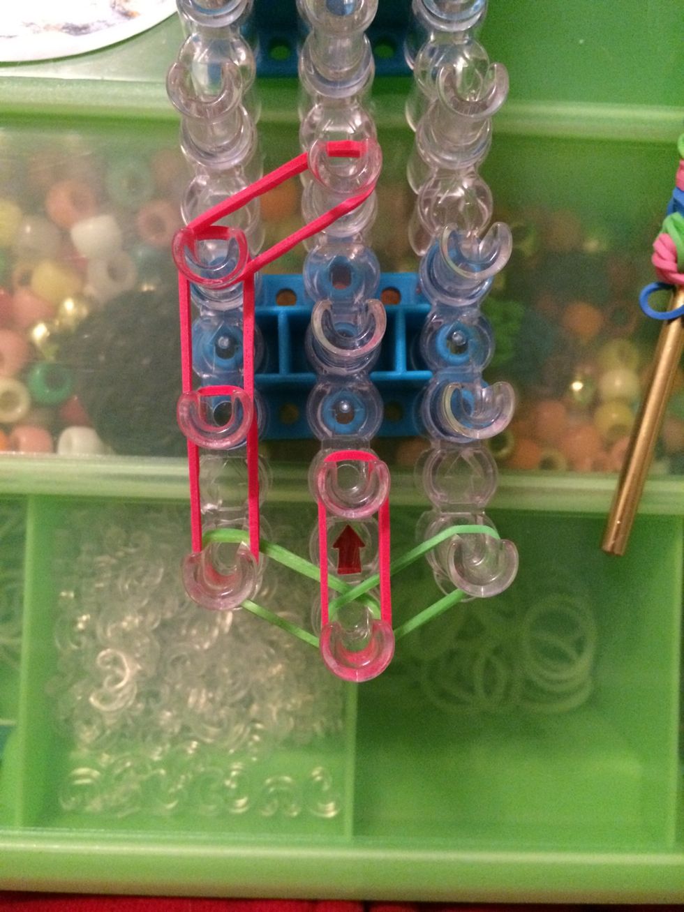 Take 2 red bands and place them on the first and second peg on the center row.