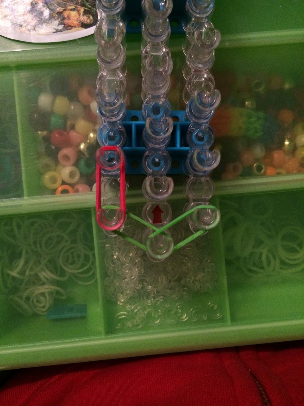 Take 2 red bands and place them one the first and second pegs on the left side.