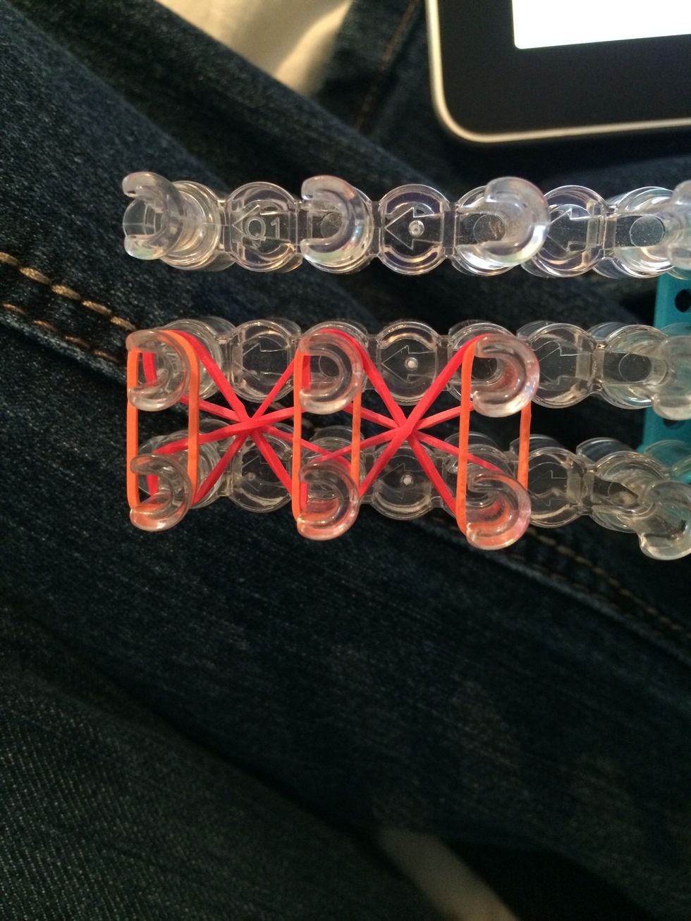 Take 3 bands of your next color and place them on the loom like this. Push down the bands.