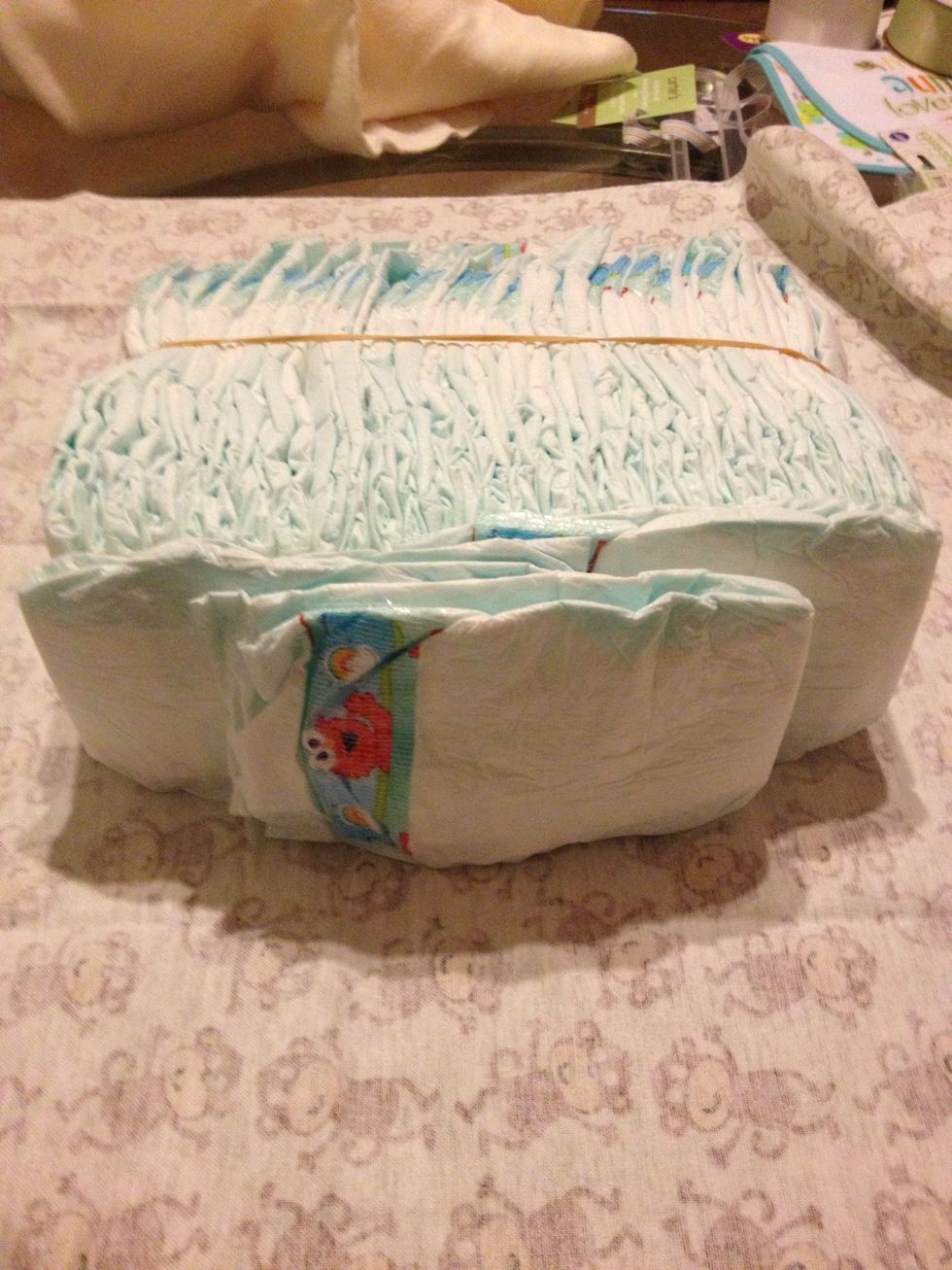 Take 3 diapers for each side to make a bed shape and put them inside the rubber band.