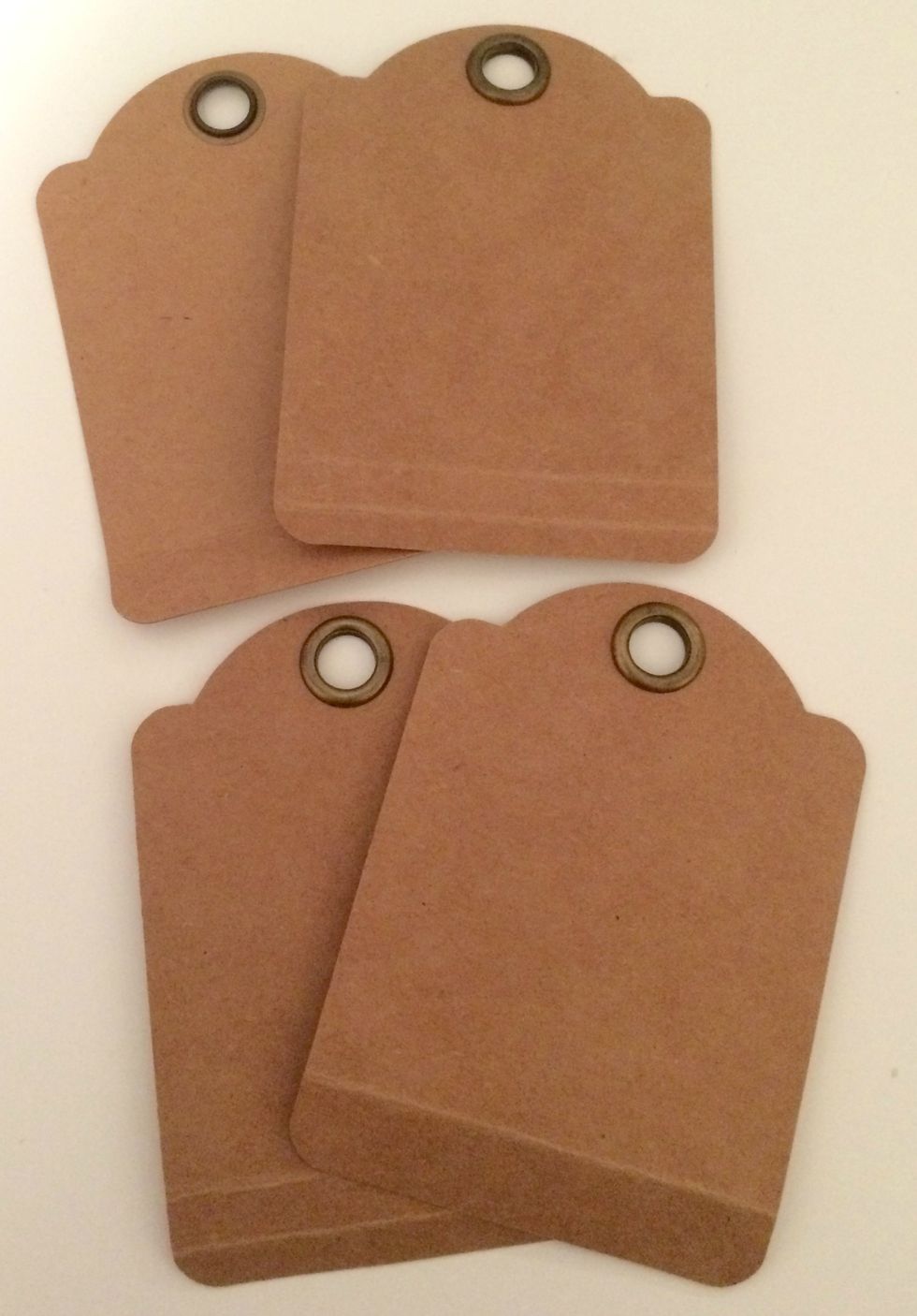 Take 4 tags from the ATC Kraft Tags package. On each tag, score 1/2" from the bottom. Fold the bottoms up.