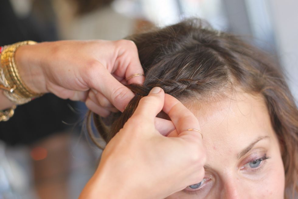 Take a 2 inch section on the top from your dominant part, and begin to inside out French braid. To do this, take strands and twist them out and under the braid, instead of over and in.