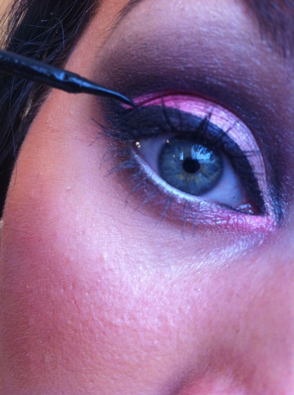 Take a black liquid eyeliner to create a harsh eyeliner flick! Now take a small amount of the black eyeliner to apply to the inner corner of the water line.