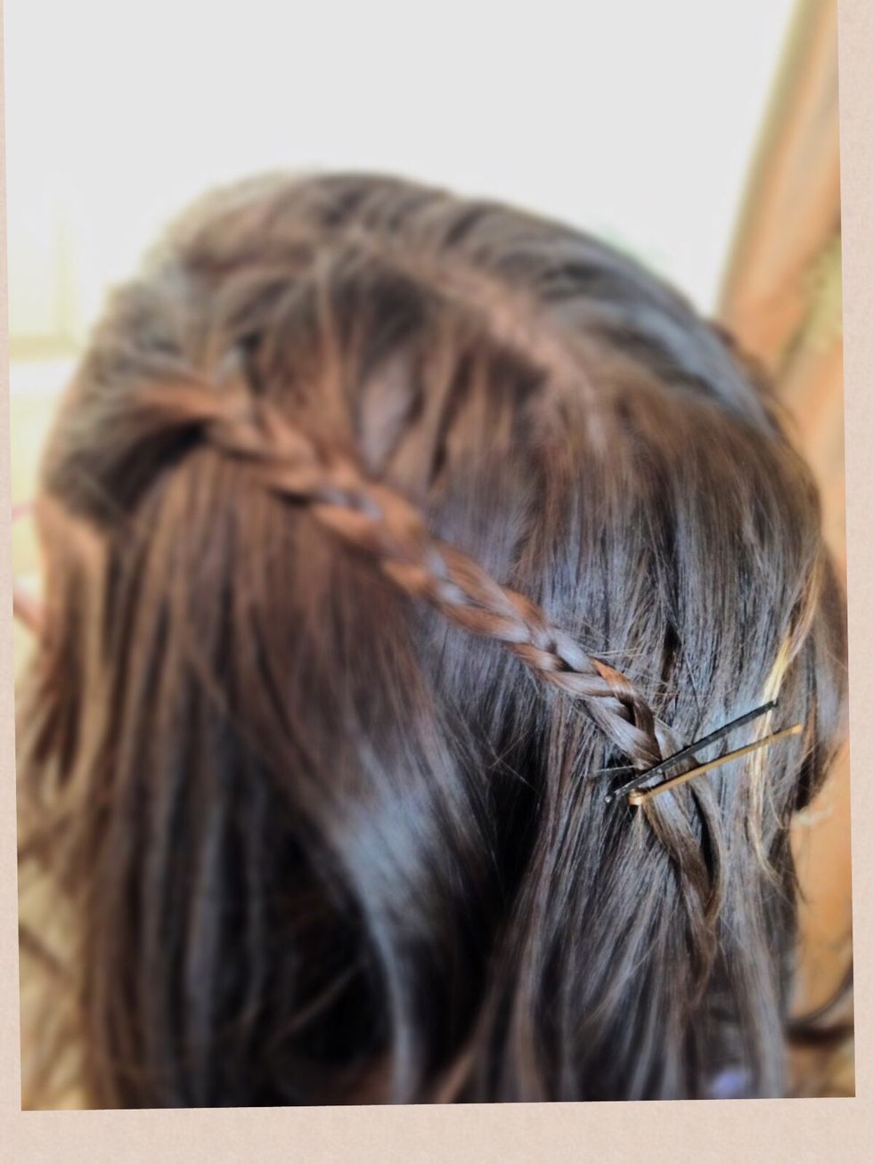 Take a bobby pin (or two) and pin both the braids back like this.