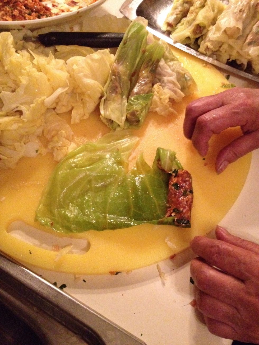 Take a cabbage leave, cut in half and take out the hard white stem. Then fill it with your filling and start rolling.