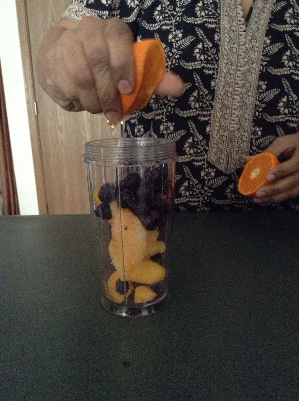 Take a clementine or a orange and cut it in half. Then squeeze in your first half of the juice of it into the cup.