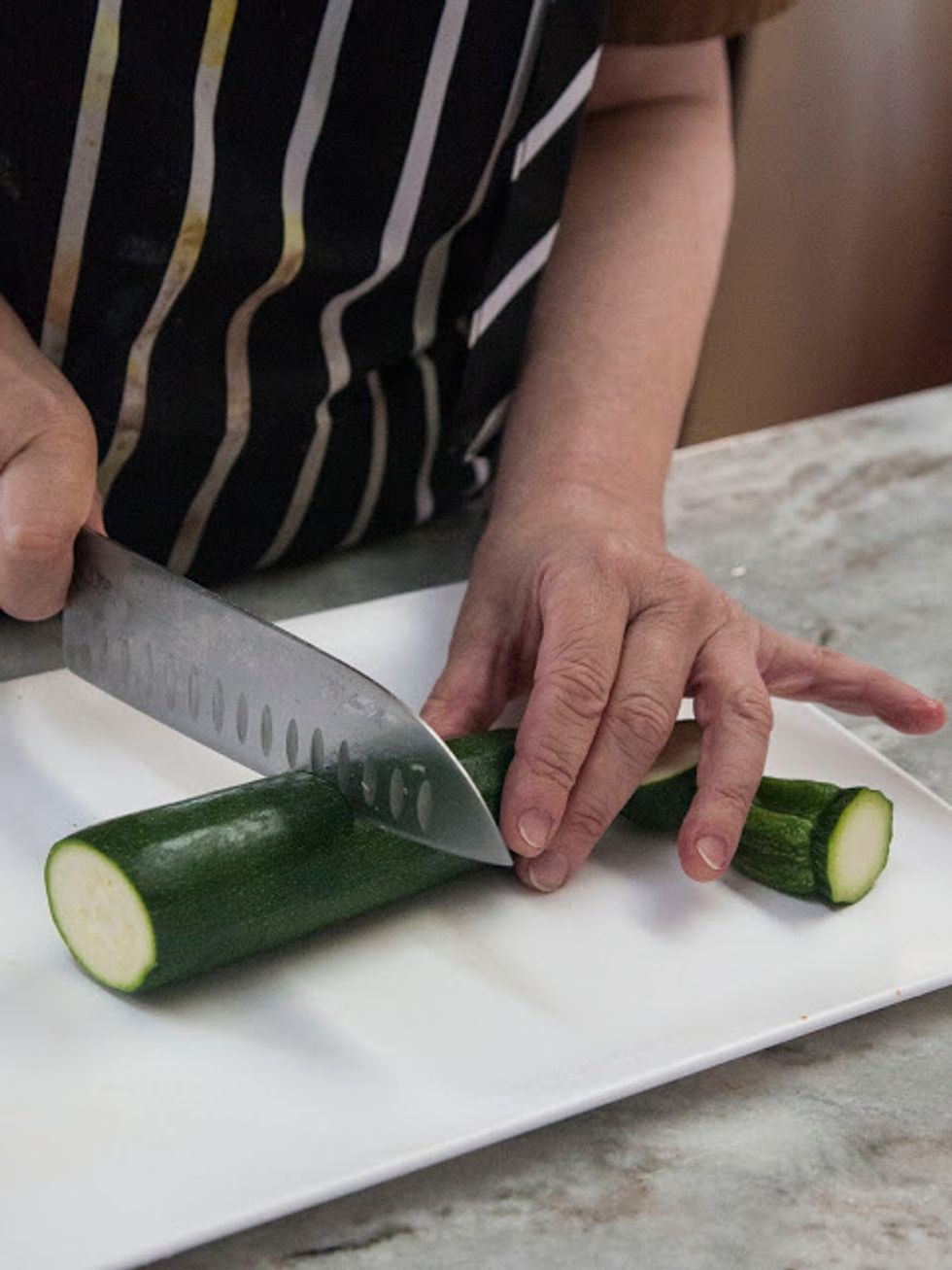 Take a couple of large zucchini and wash them well. Cut off each end, then cut the zucchini in half.