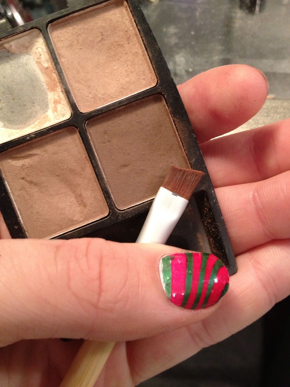 Take a dark brown or black eyeshadow and a small angled brush.