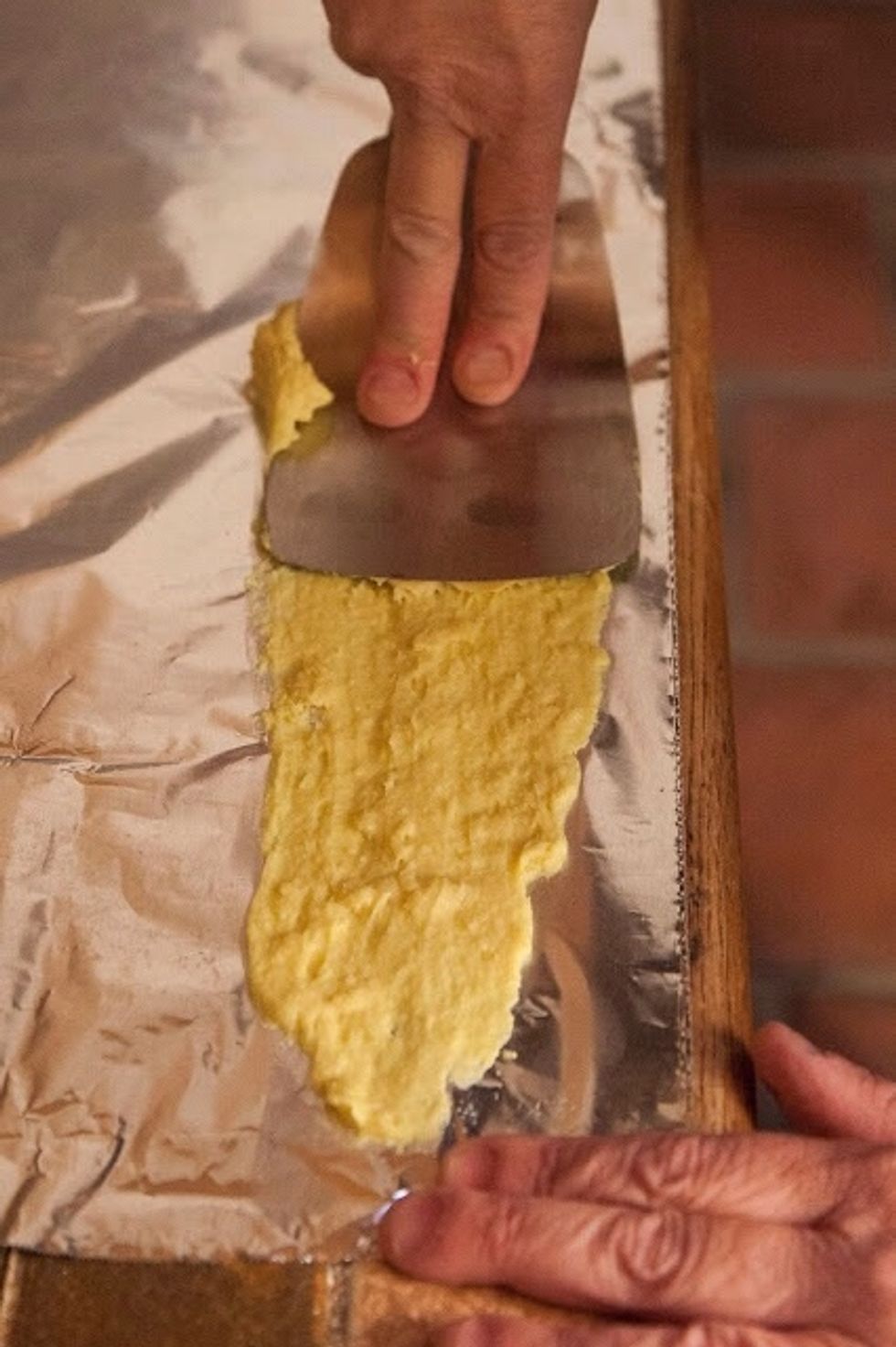 Take a flat edged spatula and spread the strip of batter down the foil, almost as though you were plastering a wall.