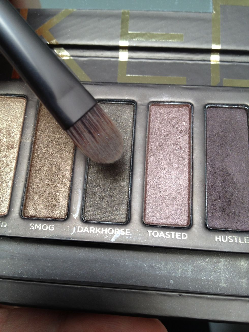 Take a flat eyeshadow brush and take the dark brown color again.