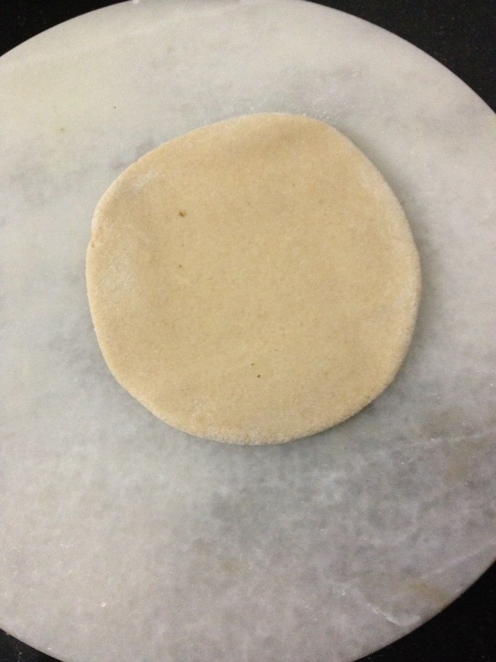 Take a lemon size ball of dough and roll it in dry flour and start to roll