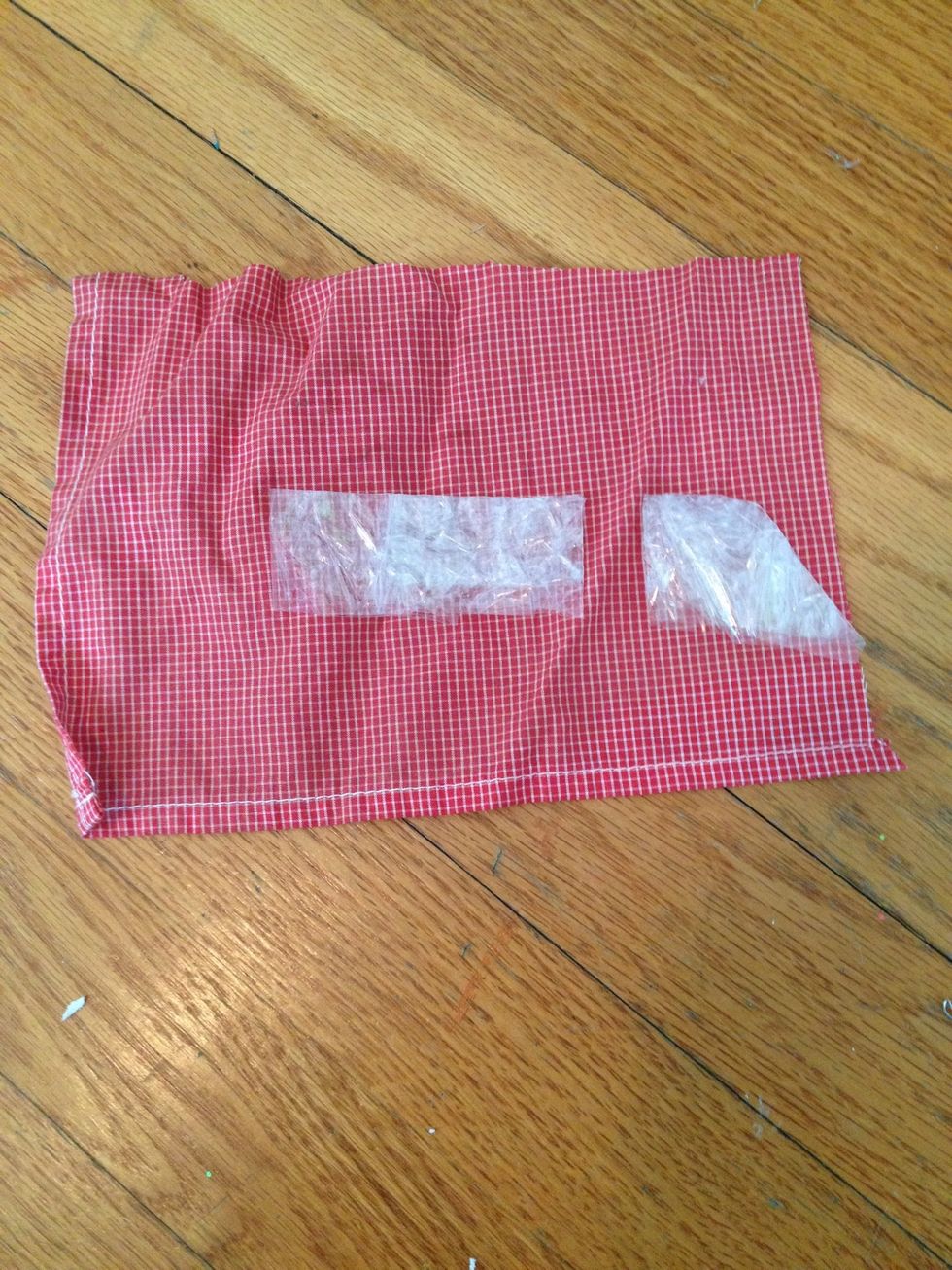 Take a lower half piece from earlier, and cut it like this. Take the longer piece and lay it on the red fabric.