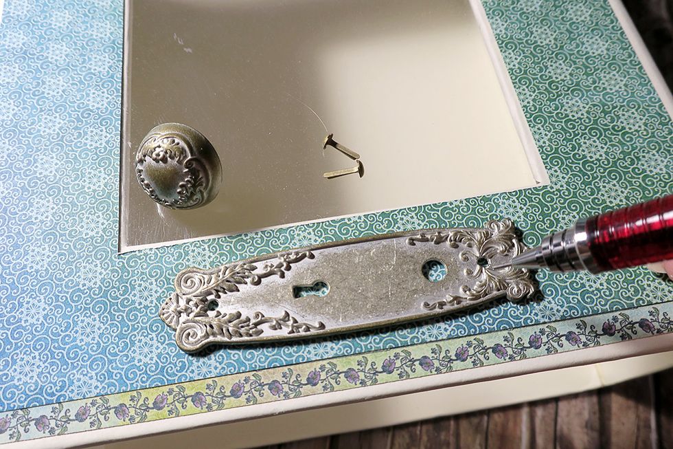 Take a metal door plate. Use your pencil for marking the places for the brads.