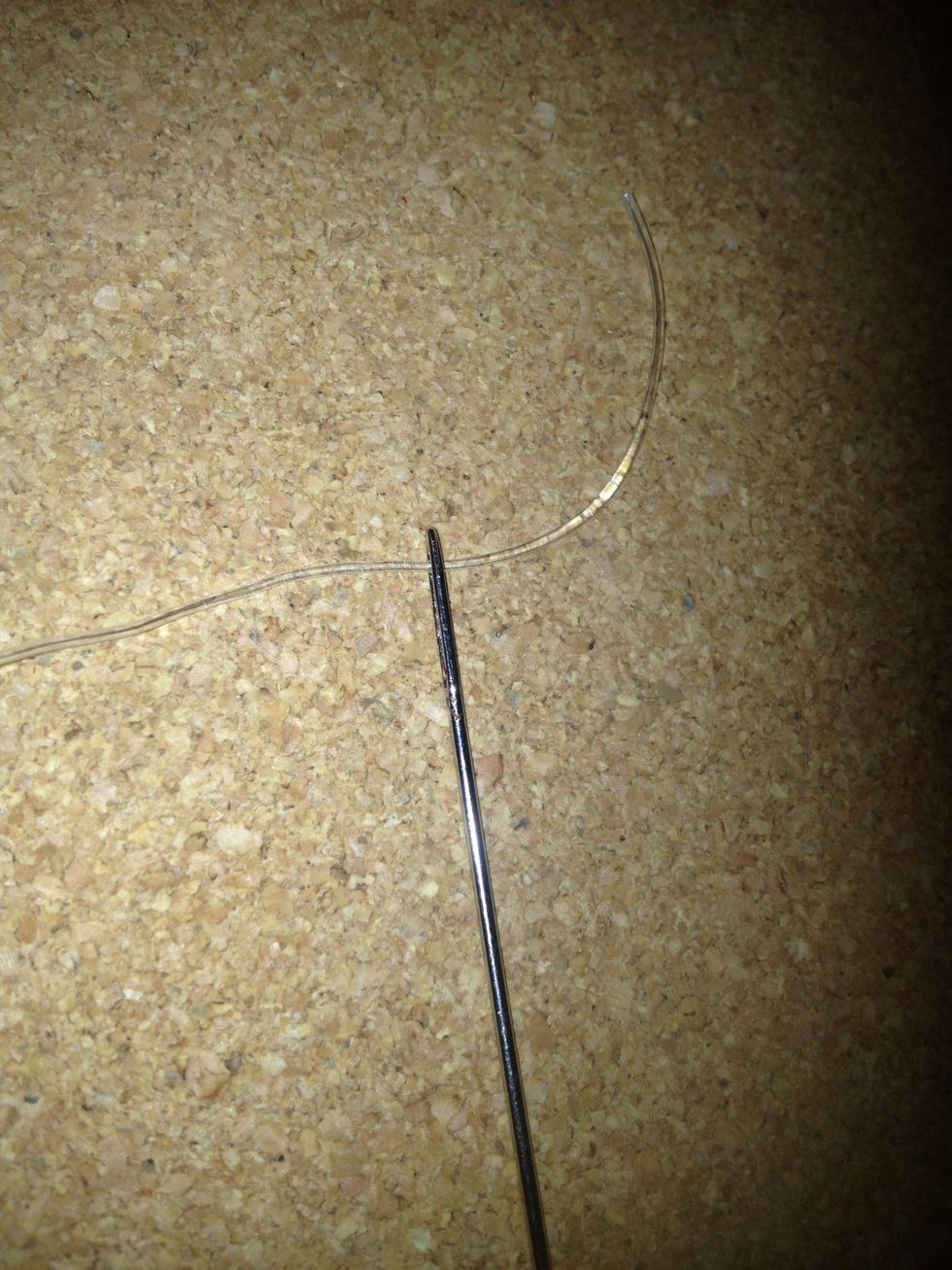 Take a needle that has a big enough whole to put the stretchy cord through. By using a needle it will make it easier to thread the cord through the lucky star.