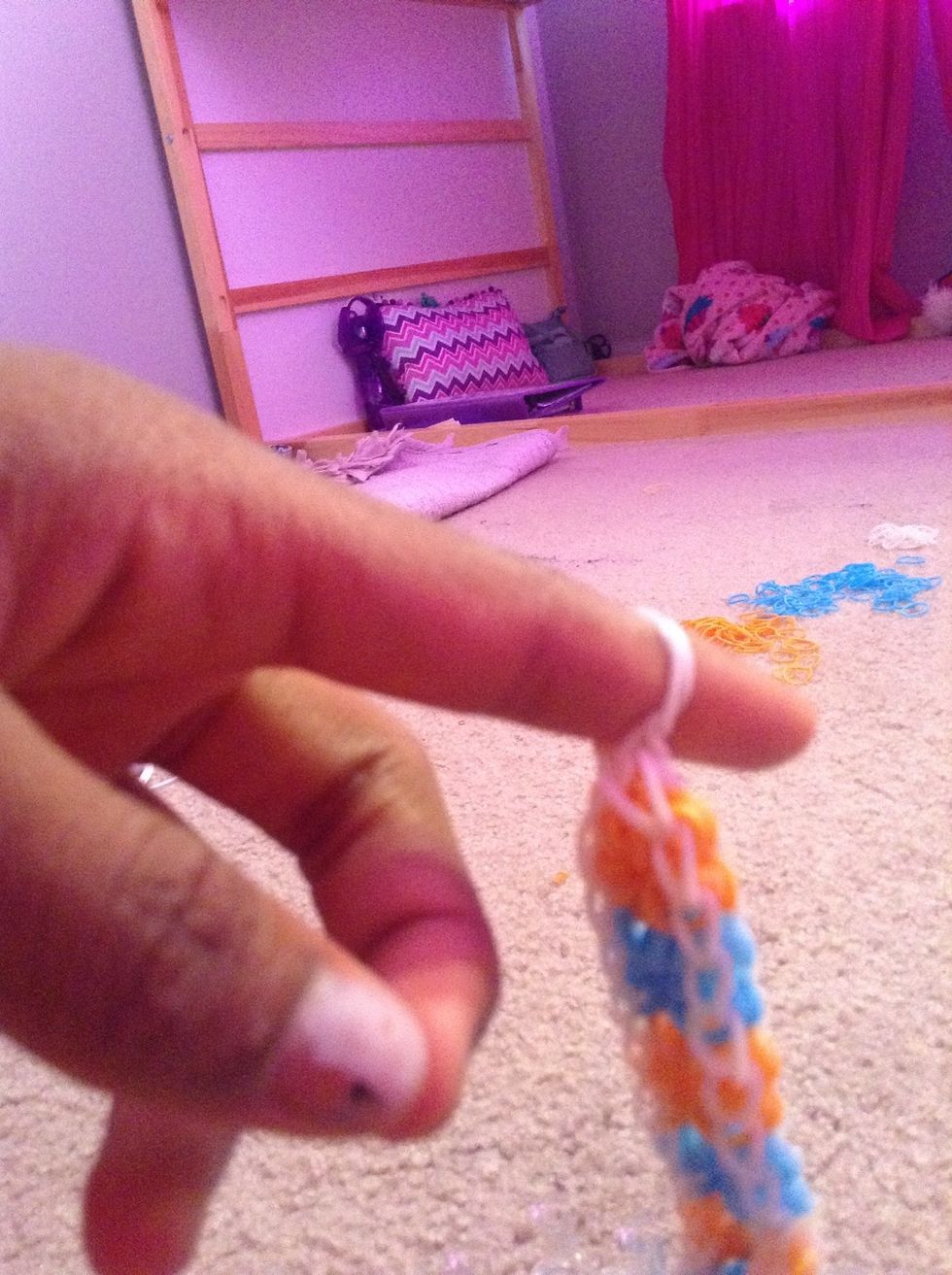 Take a new rubber band and put it through your rubber band already in your finger